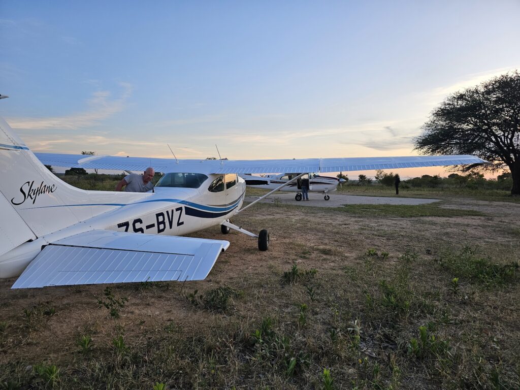 A light aircraft on the grass at sunset.