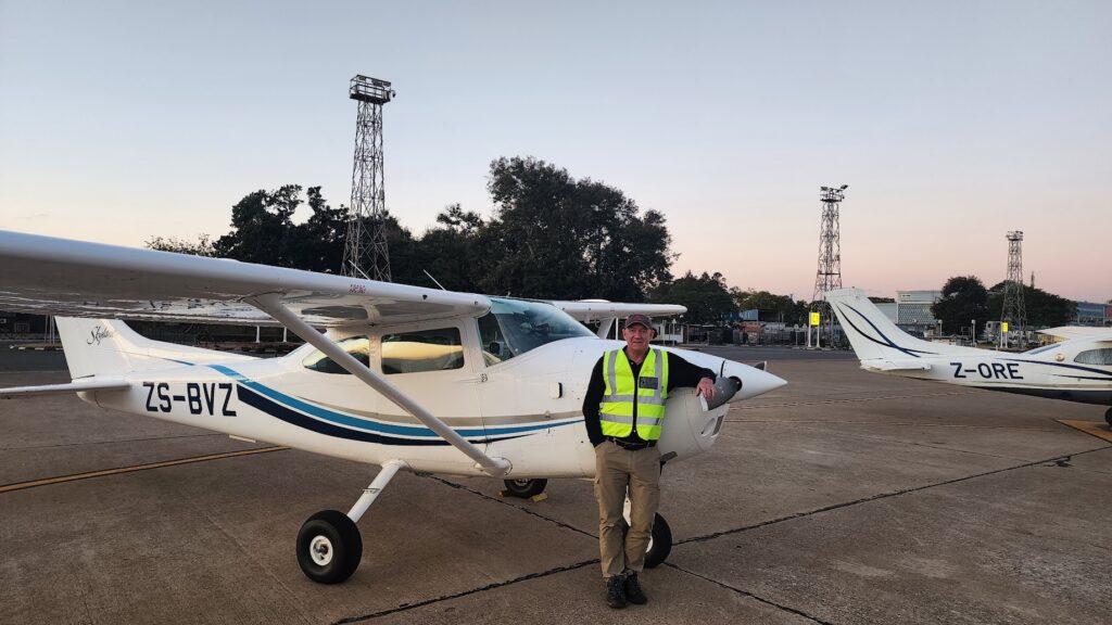 A man in a reflective vest beside aircraft ZS-BVZ.
